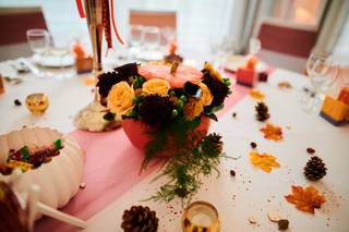 centre de table avec feuilles séchées sur la table et un bouquet de roses mixte