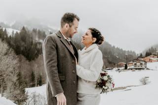 couple de mariés homme et femme dans la neige, femme qui porte des bottes brunes