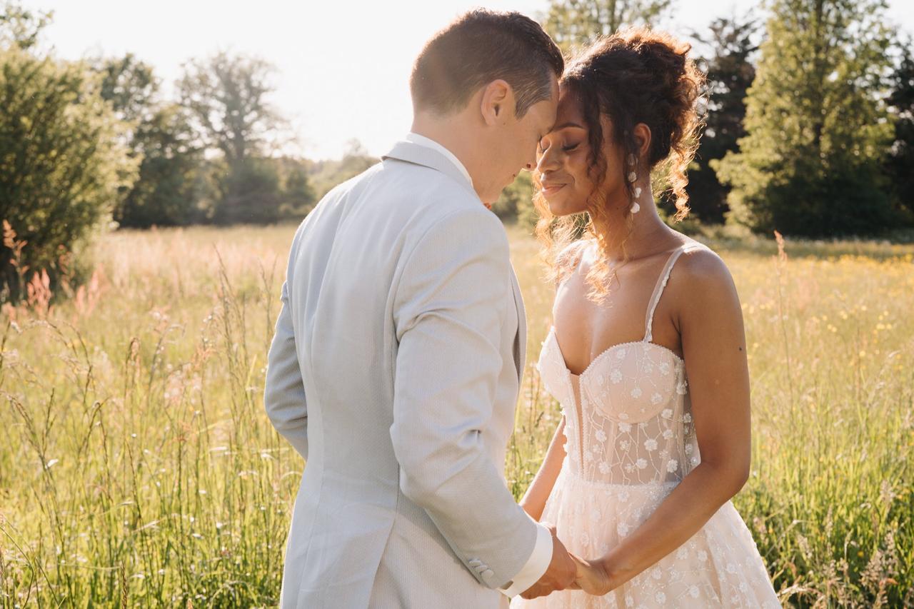 couple de mariés homme et femme vetus d'un costume et d'une robe, dans les champs, mariage champetre, couple se donnant les mains, citation mariage heureux, citation mariage bonheur couple marié