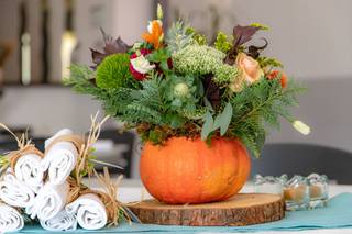 centre de table avec citrouille et plantes vertes