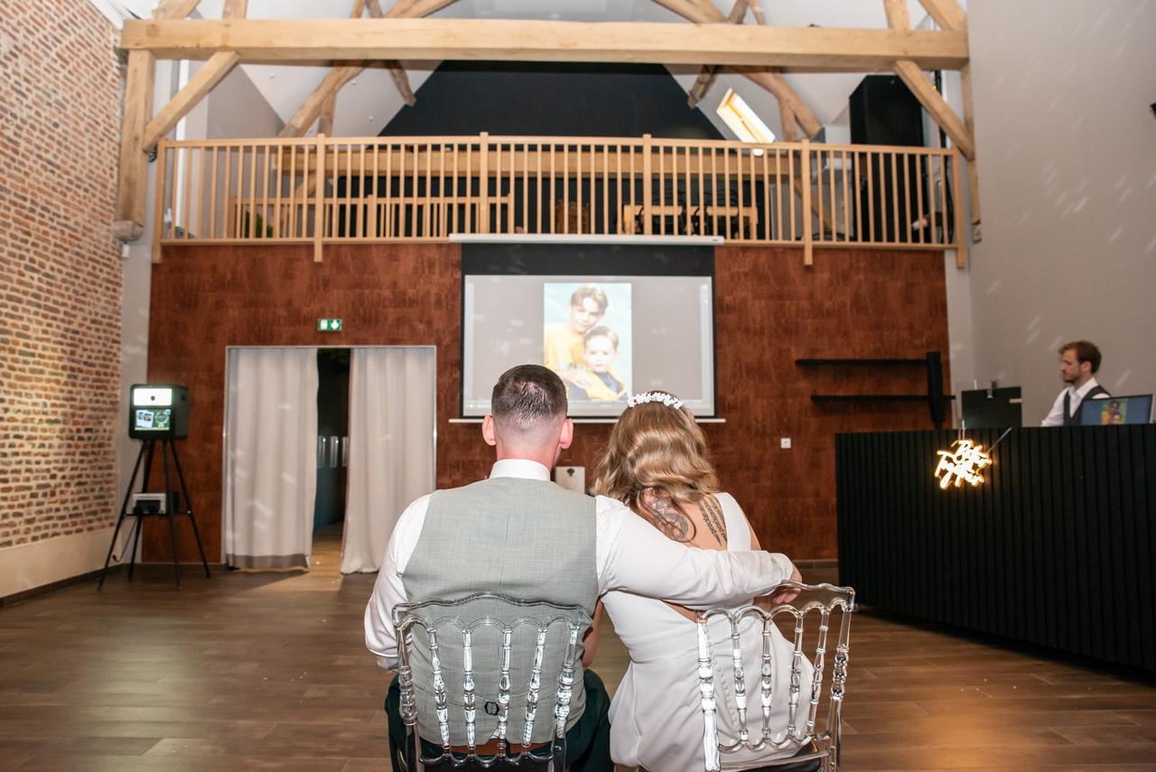 video de mariage, mariés en train de visionner une video de mariage surprise avec souvenirs d'enfance, mariés etant jeunes, film d'enfance video pour mariage