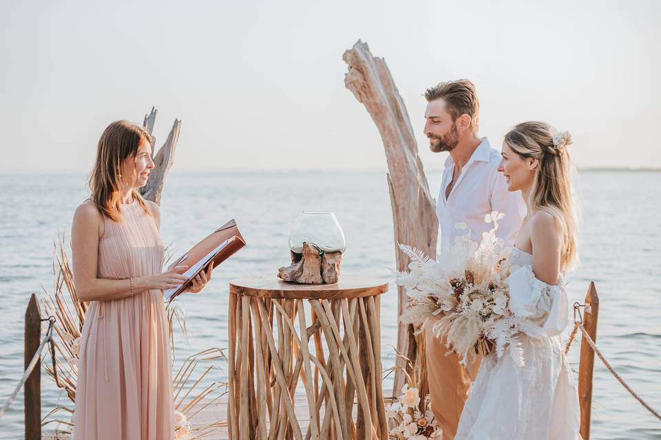 officiante de cérémonie avec les mariés sur la plage