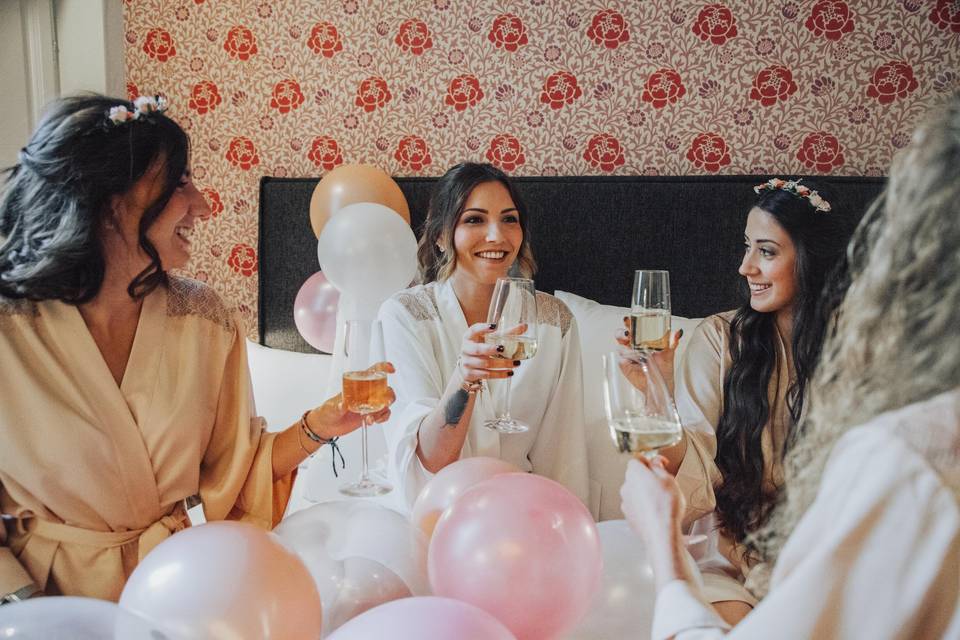 mariée trinque avec du champagne avec ses copines en peignoir