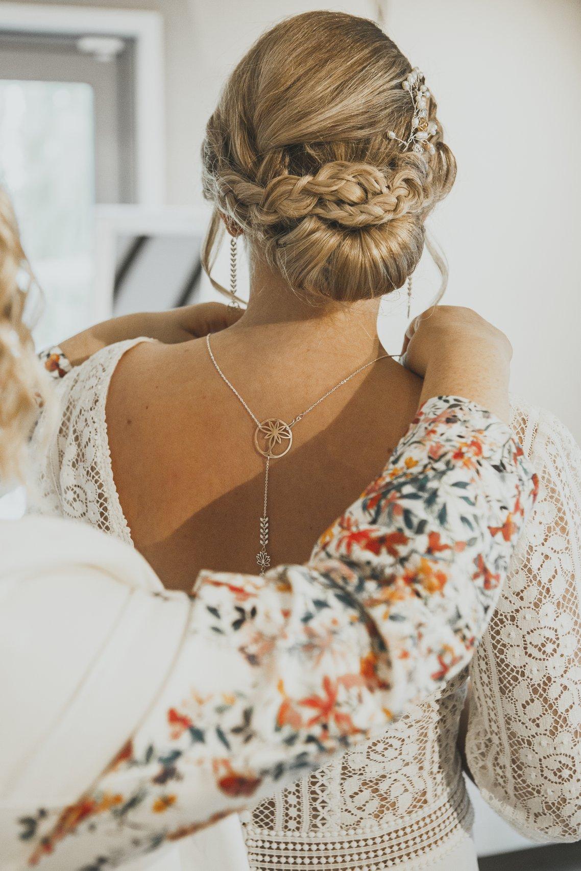 femme en robe blanche portant un collier de dos