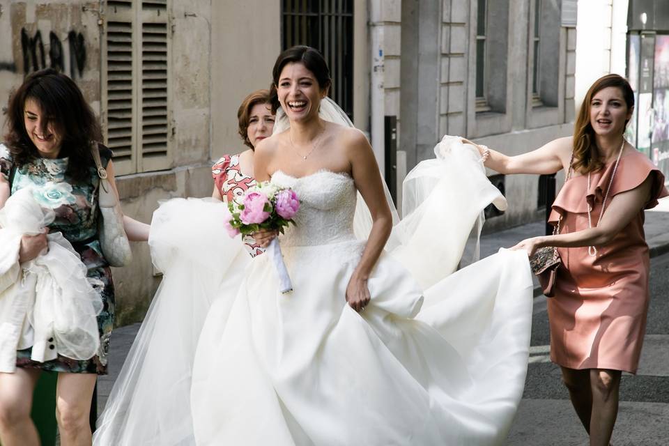 mariée en robe blanche avec traine entourée de ses amies