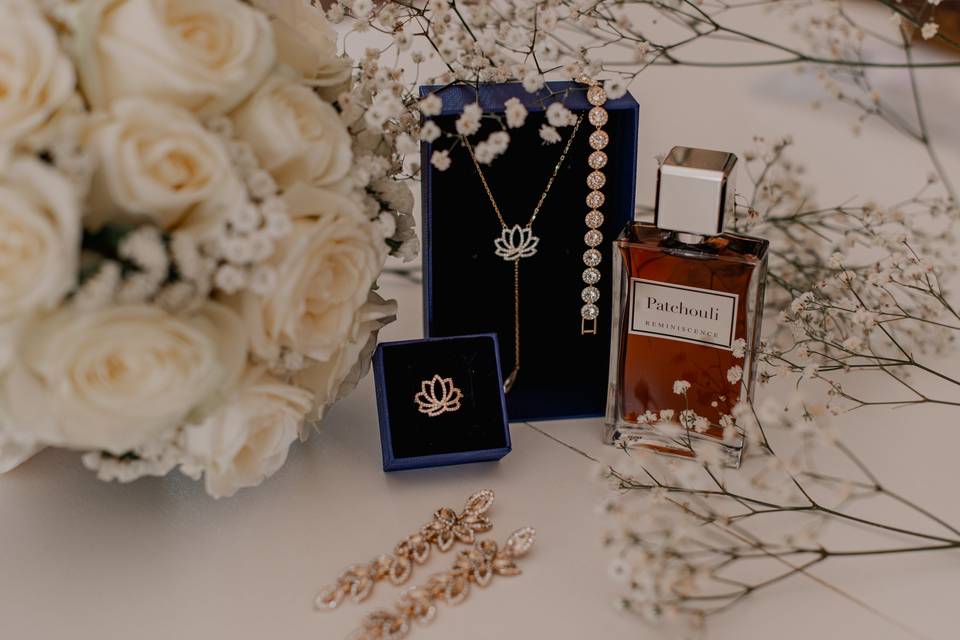 accessoires de la mariée : bouquet de fleurs blanches, parfum, boucles d'oreilles, collier