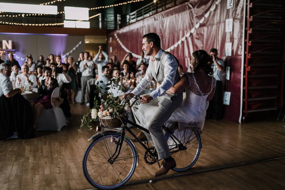 homme et femme en tenue de cérémonie sur un vélo décoré de fleurs