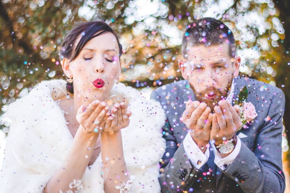 couple de mariés soufflent sur des paillettes