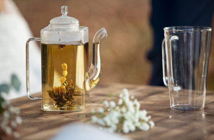 théière en verre avec fleur de thé ouverte