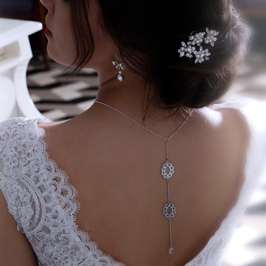 femme en robe blanche portant un collier de dos