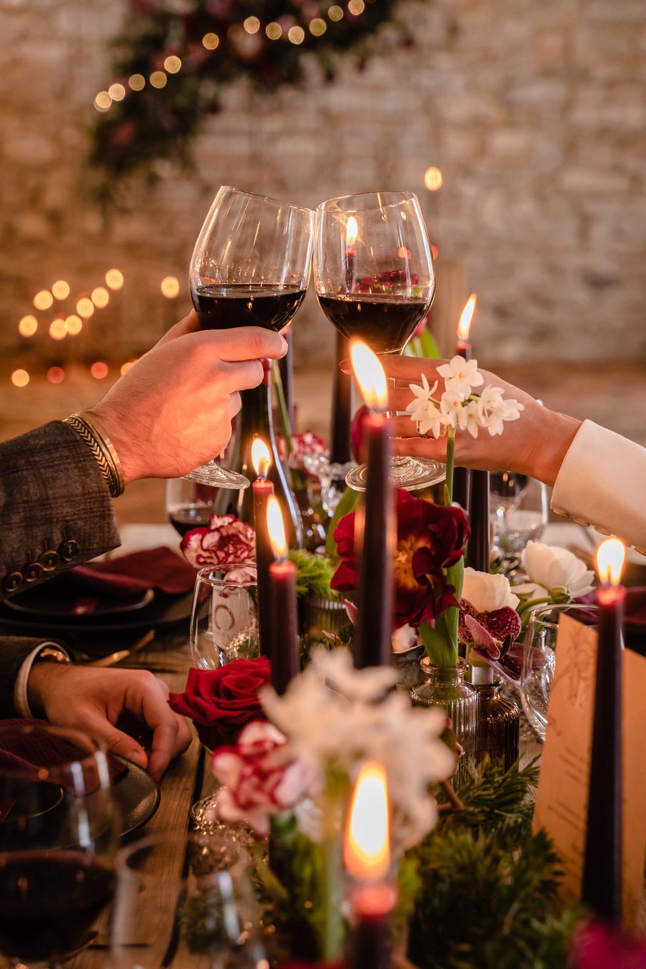 mariage en hiver, table mariage decoree theme hiver avec mariés qui trinquent avec leur verre de vin rouge