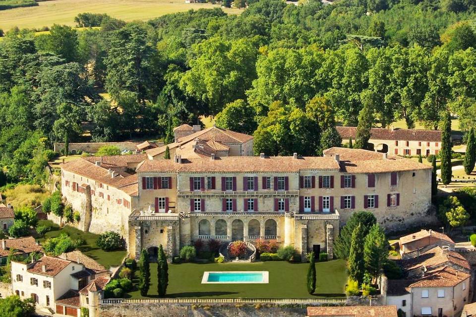 splendide paysage avec château en gros plan. On observe une nature abondante et une piscine devant le château. Lieu idéal pour mariage en plein air