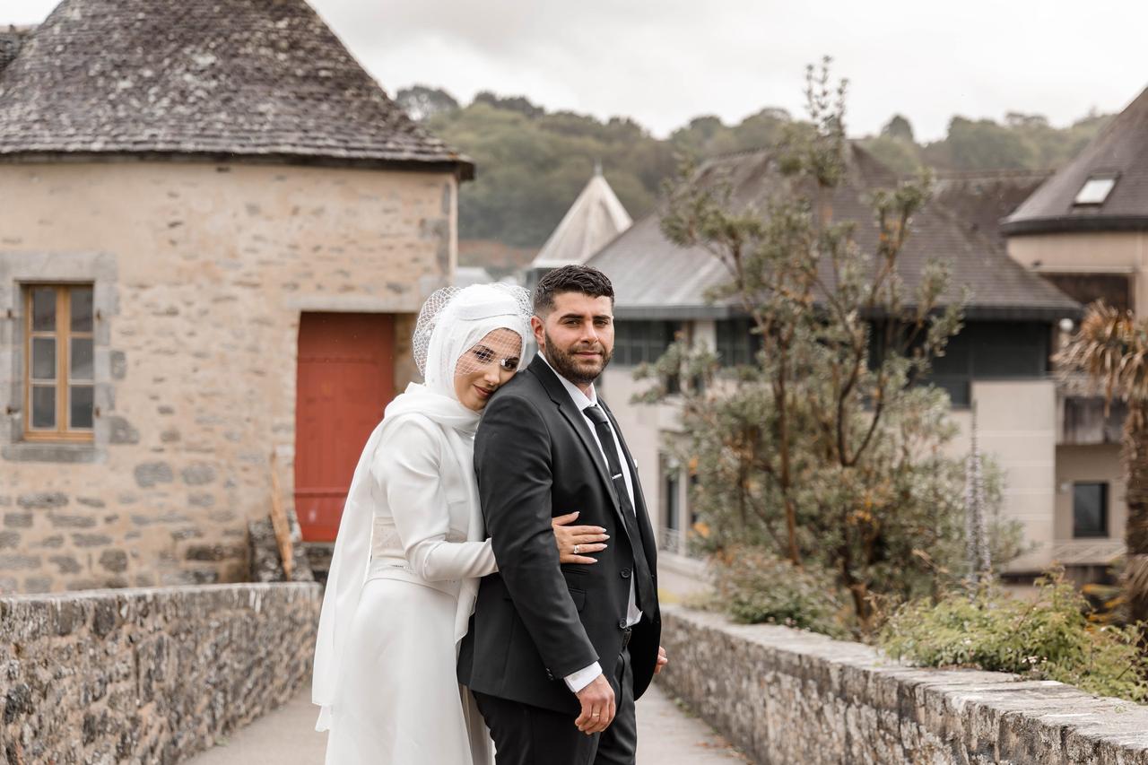 Couple de marié musulman la mariée porte une robe blanche avec un voile et le marié un costume noir