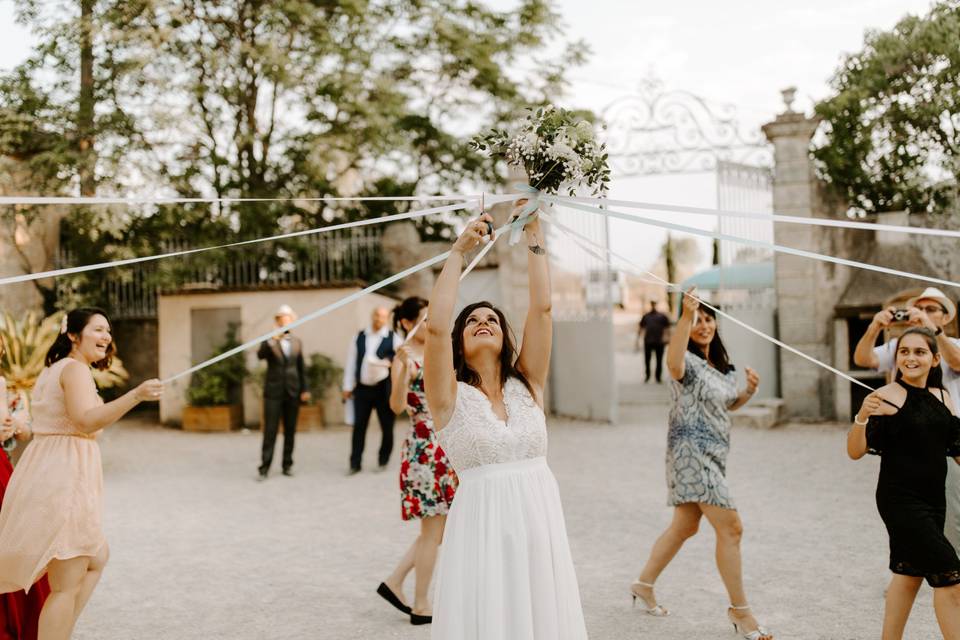 mariée en robe blanche au centre et entourée de ses copines, en train d'organiser le jeu du ruban. cérémonie du ruban. ronde des rubans de la mariée.