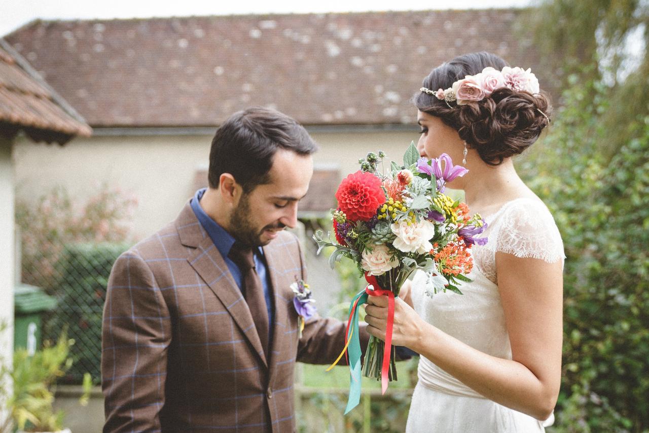 coiffure de mariée sur le côté avec chignon bouclé et fleurs décoratives