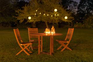 lumière mariage avec bougie sur la table et lampes en papier dans l'arbre