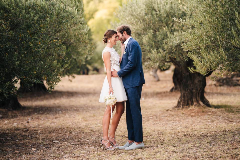 Couple de mariés, la mariée porte une robe courte blanche avec corset en dentelle, le marié un costume bleu - petis cohes qui font craquer un homme