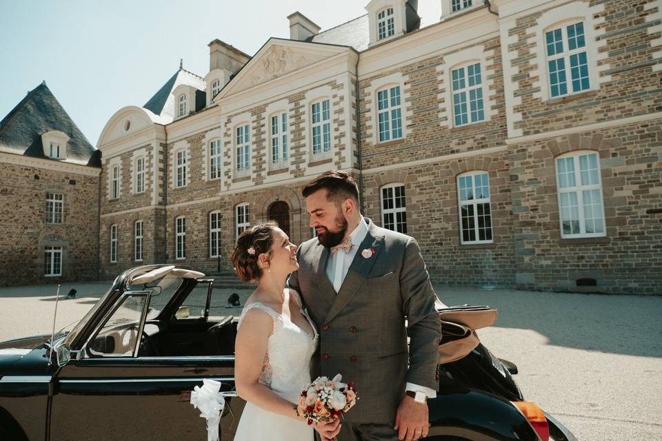 Couple de marié près d'une voiture vintage