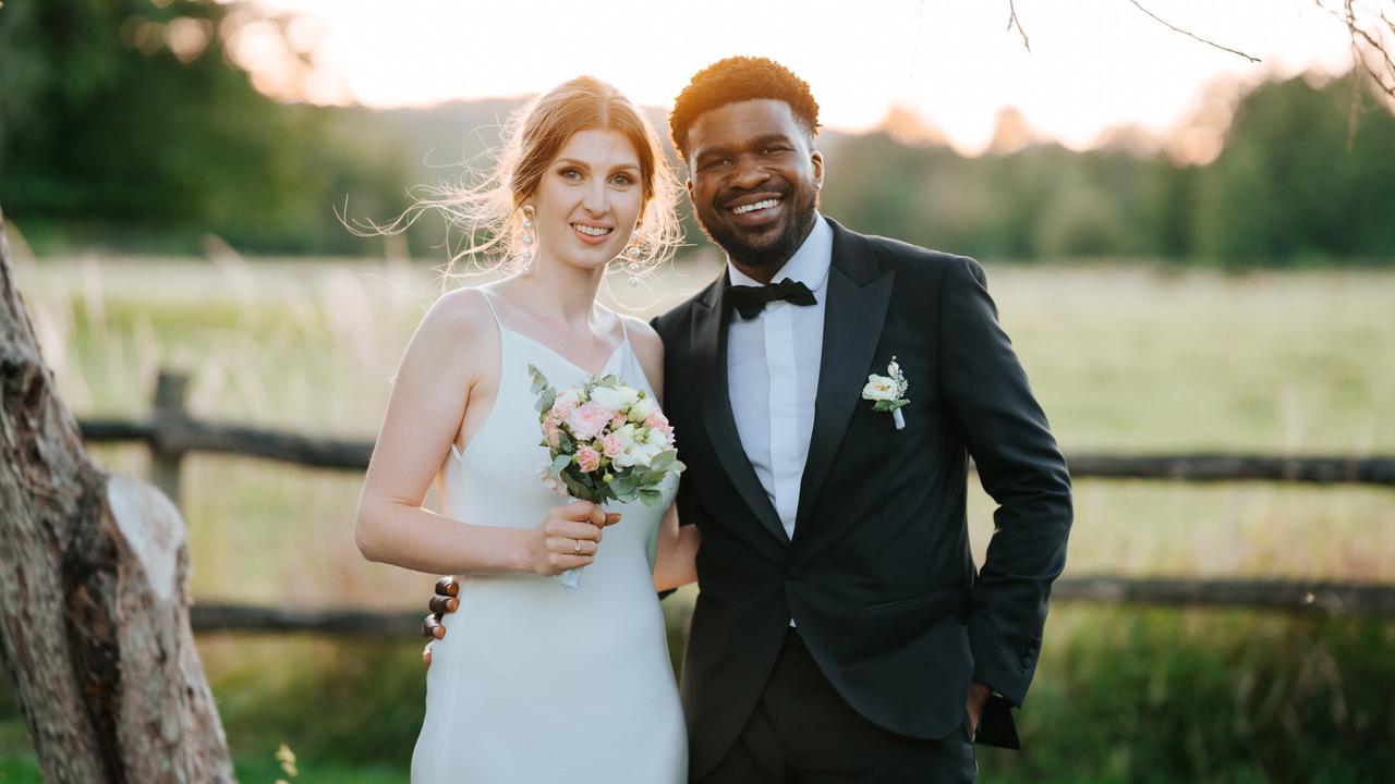 photo d'un couple de mariés mixte et la mariée à un bouquet mariages.net
