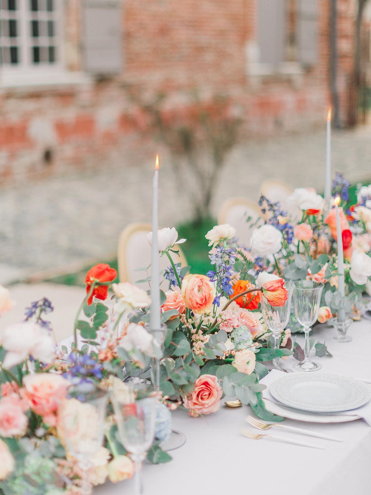 lumière mariage avec chandelier en centre de table et fleurs couleurs pantone 2024 peach fuzz