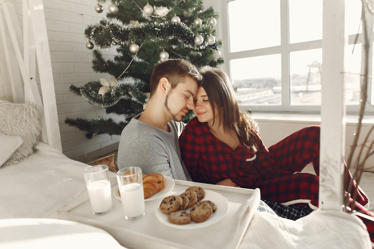 couple en pyjama a cote du lit, matin de noel, petit dejeuner romantique de noel pour faire demande en mariage