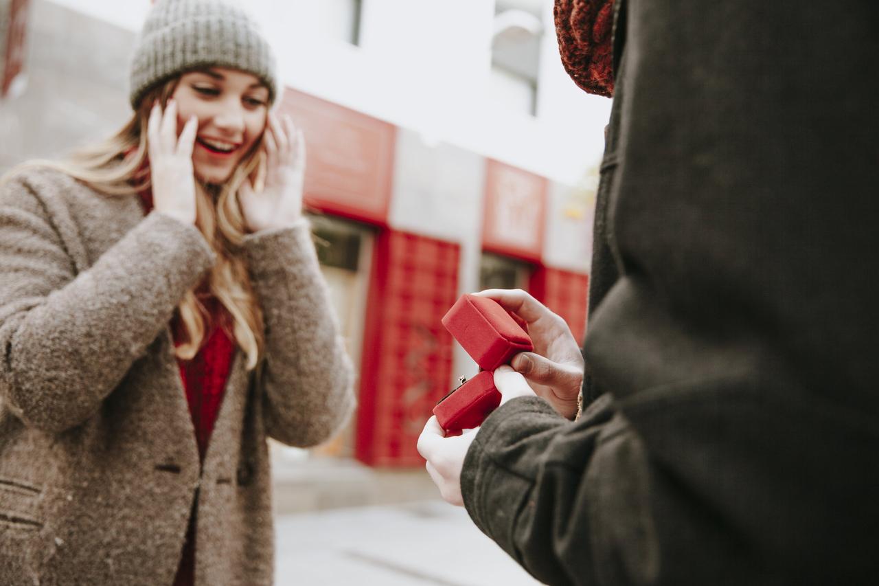 demande en mariage pour noel sous forme de jeu amusant, devinette, homme qui tend une petite boite rouge avec une bague a sa copine, veux tu m'epouser