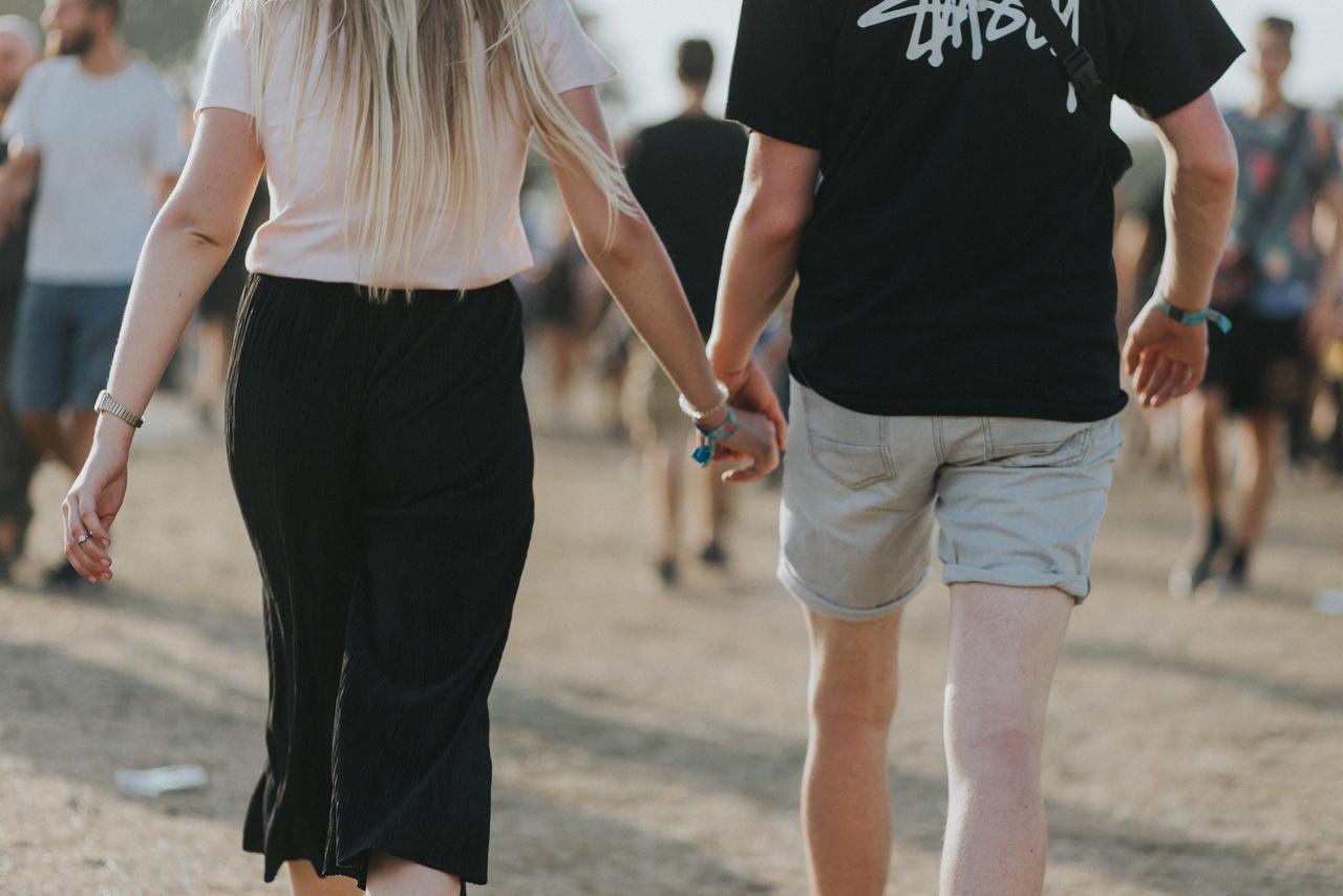 Couple qui se tient la main et marche pendant un festival de musique