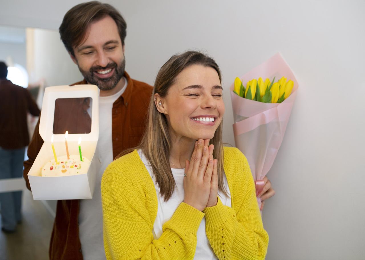 couple qui célèbre son anniversaire, homme offre a sa femme un gateau et des fleurs