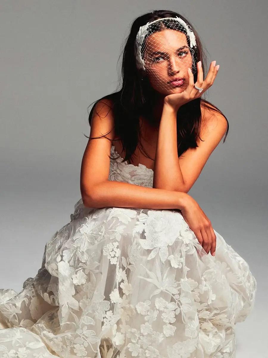 mariée avec mini voile sur les yeux et robe brodée fleurs blanches