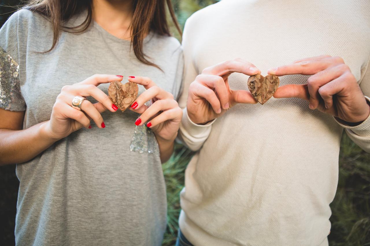 L'homme et la femme tenant des coeurs en bois, chasse au trésor annonce mariage