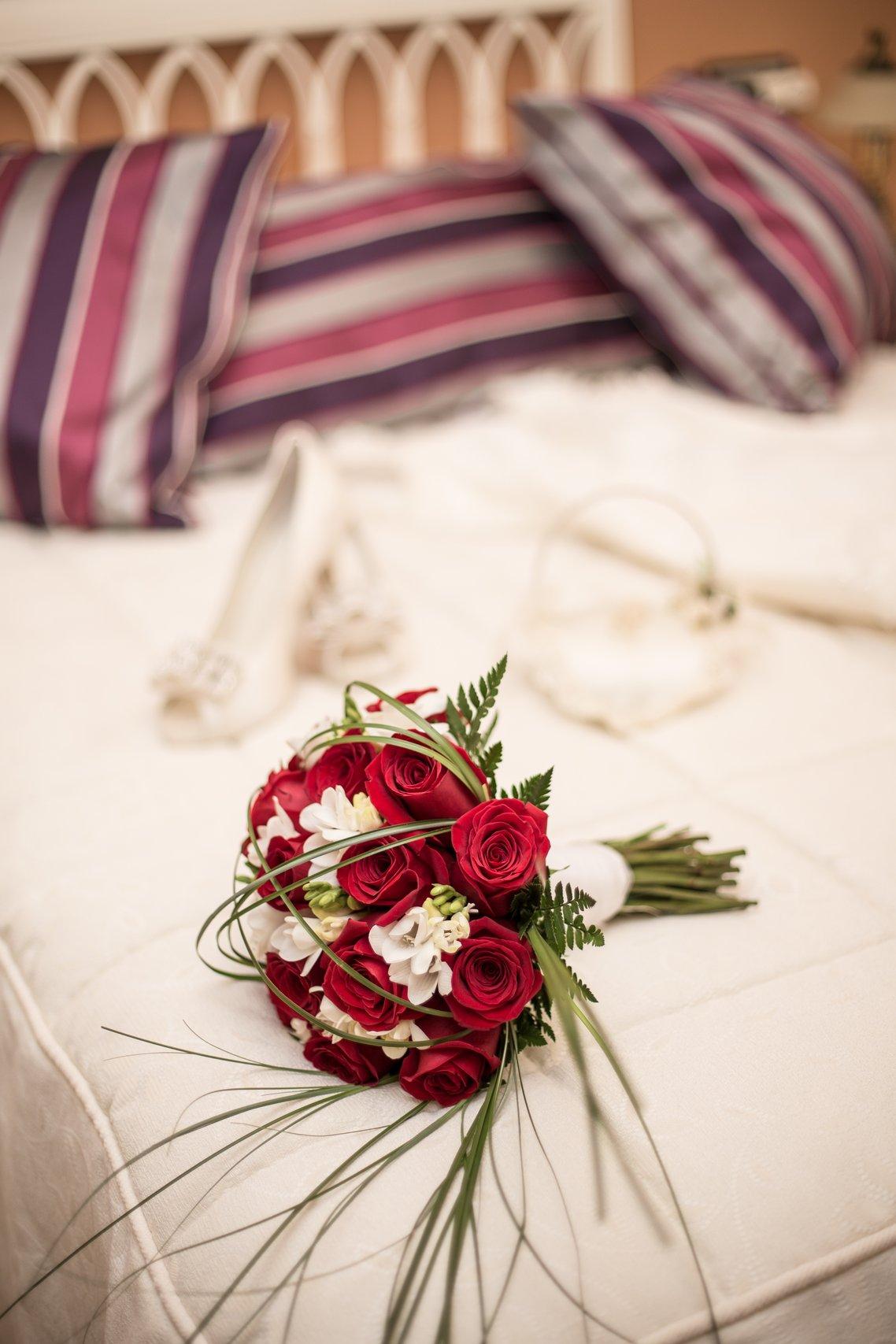 lit avec bouquet de mariée avec roses rouges, pot de chambre mariage tradition