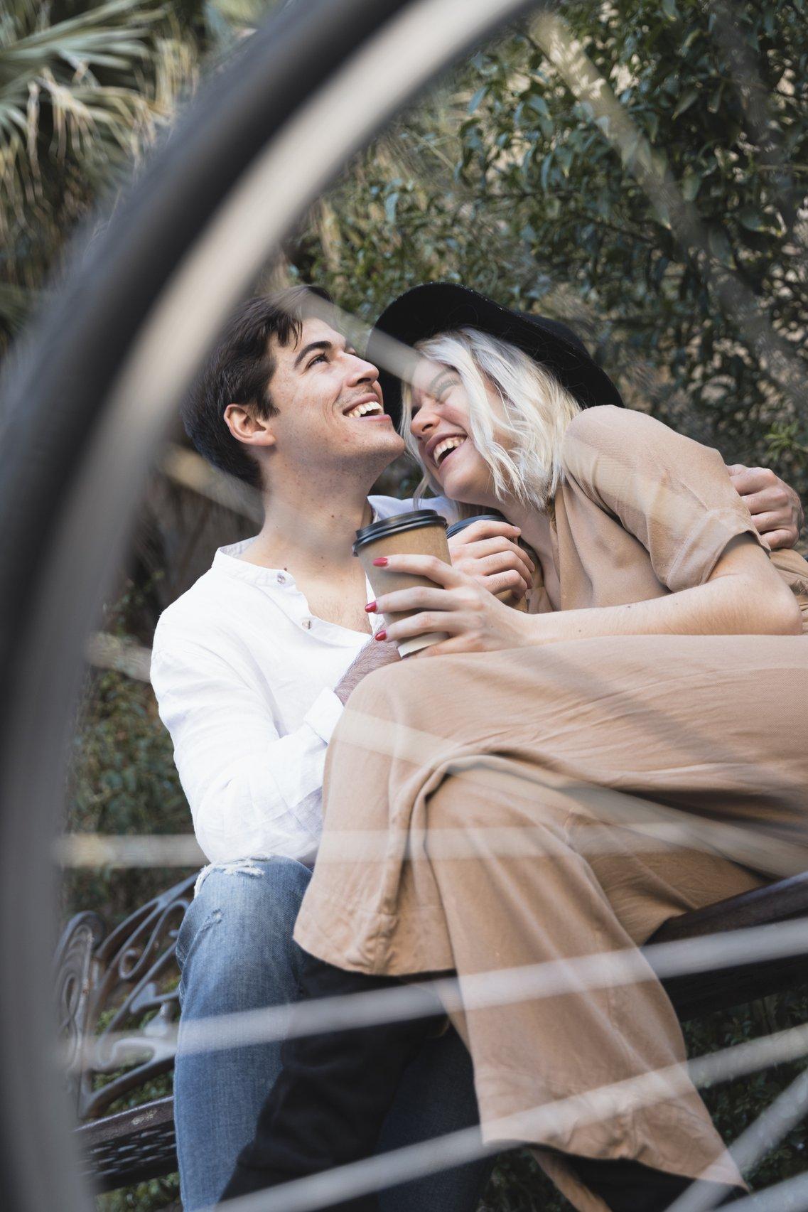 couple heureux assis sur un banc, rendre une femme heureuse et la faire sourire