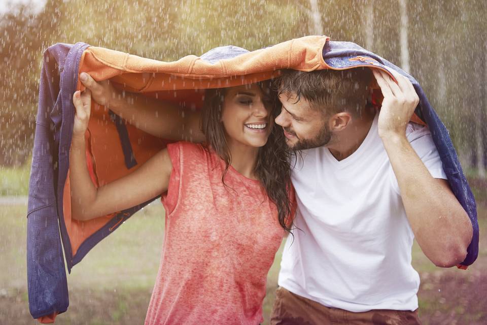 couple trempé par la pluie sous un manteau dans le cadre du jeu action ou vérité en couple, défi couple 