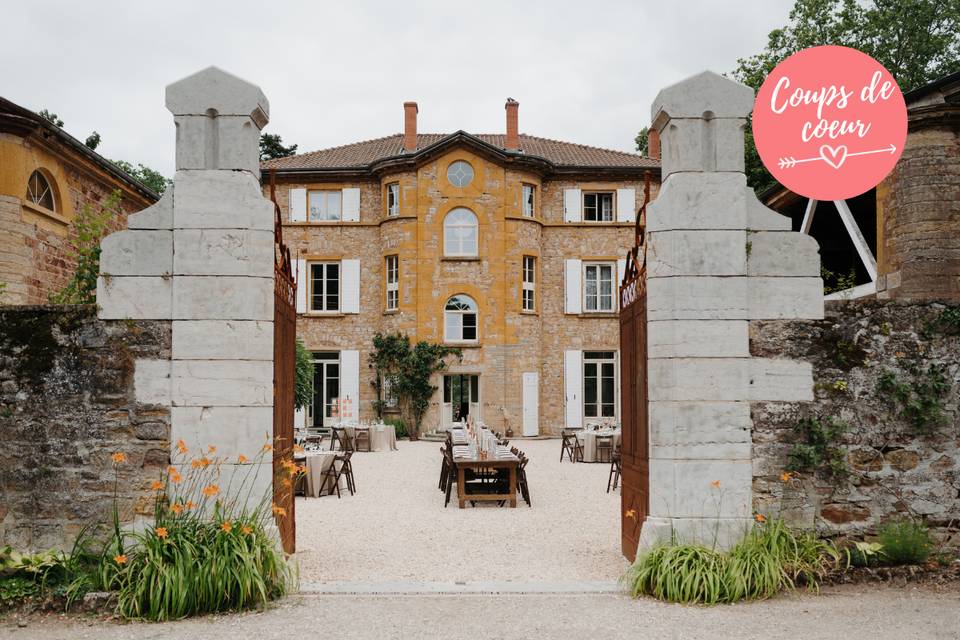 vue sur cour intérieure d'un chateau de mariage, murs en pierres, tables de cérémonie dressées, mariage lyon