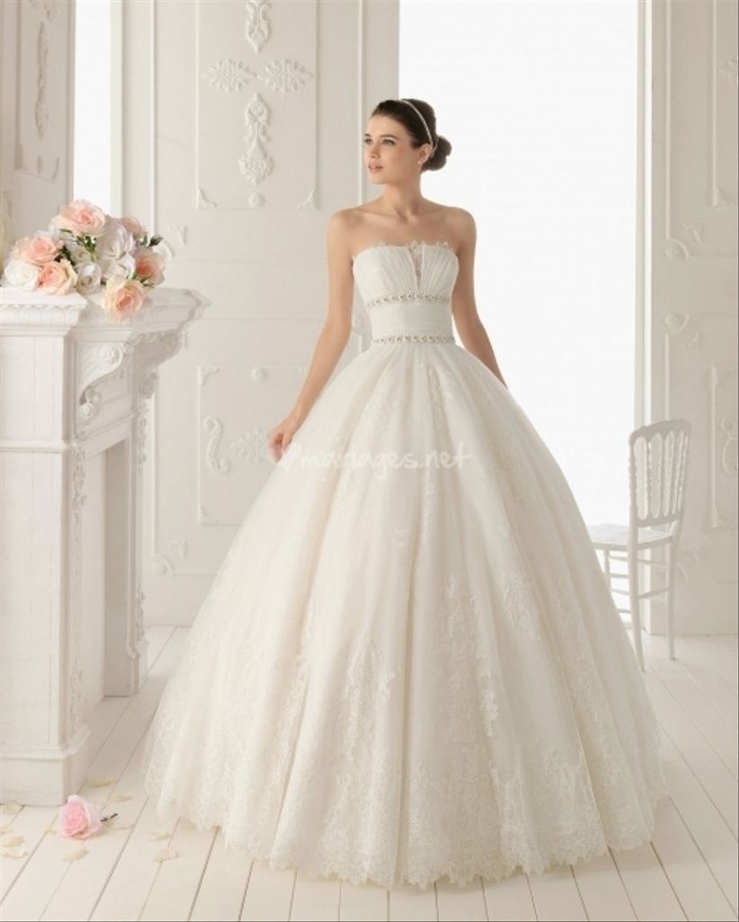 Aire Barcelona a conçu une robe harmonieuse avec bustier fendu, large ceinture et jupe bouffante terminée en dentelle dans laquelle la mariée a tout lair