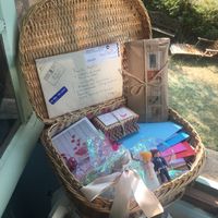 Les enveloppes des cadeaux invités dont des protèges passeport et étiquettes bagages personnalisés e