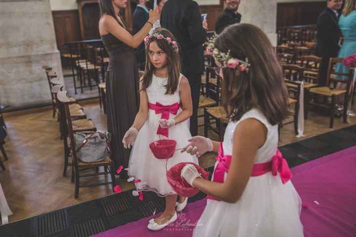Les petites enfants d'honneur laisse des pétales sur le tapis rose