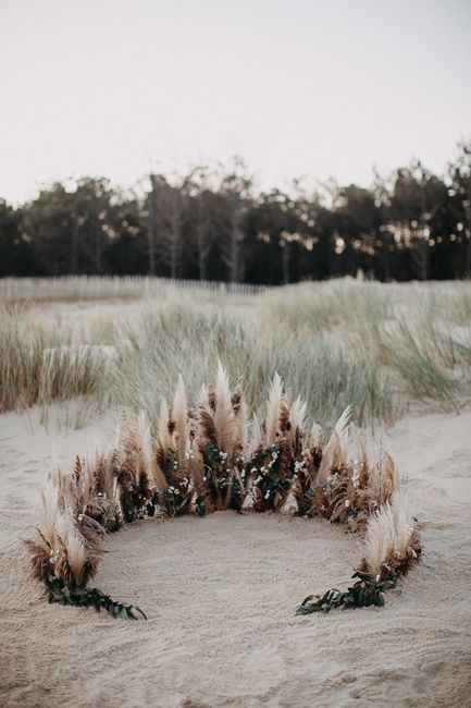 Arche avec des fleurs et plumes sur la plage