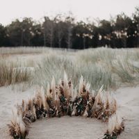 Arche avec des fleurs et plumes sur la plage