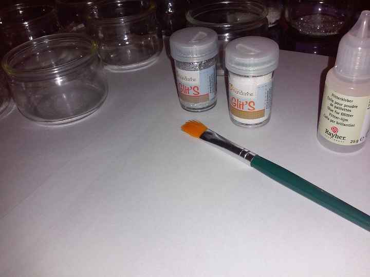 Des pots en verre, des paillettes, de la colle à paillettes, un pinceau, une feuille pour récupérer 