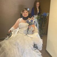 La future mariée avec son bouquet et sa petite sœur qui tient les décorations pour le fauteuil roula