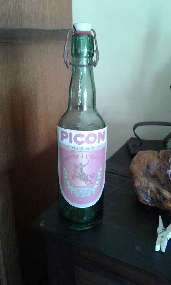 une vieille bouteille avec une étiquette Picon qui fait référence à la scène ou césar apprend à mari