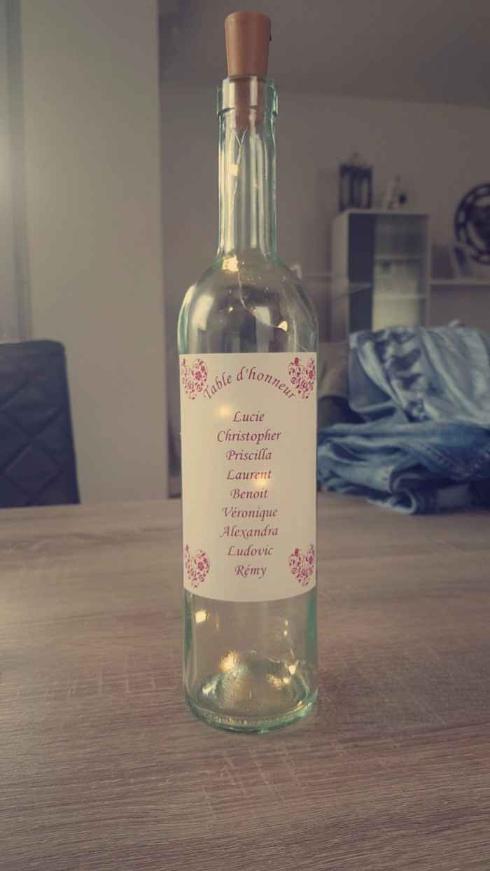 étiquette noms des invités sur bouteille de vin avec guirlande lumineuse