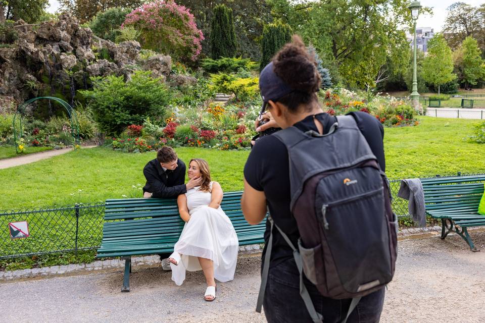 Photographe assis sur un banc photographiant le couple