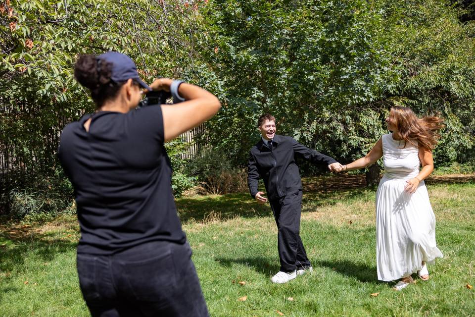 Plan large du photographe et du couple sur l_herbe
