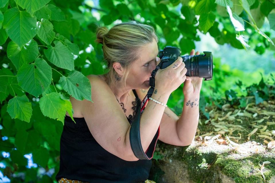 photographe milieu feuilles vertes