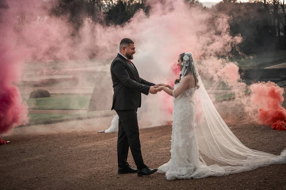 Portrait des mariés dans une fumée rose