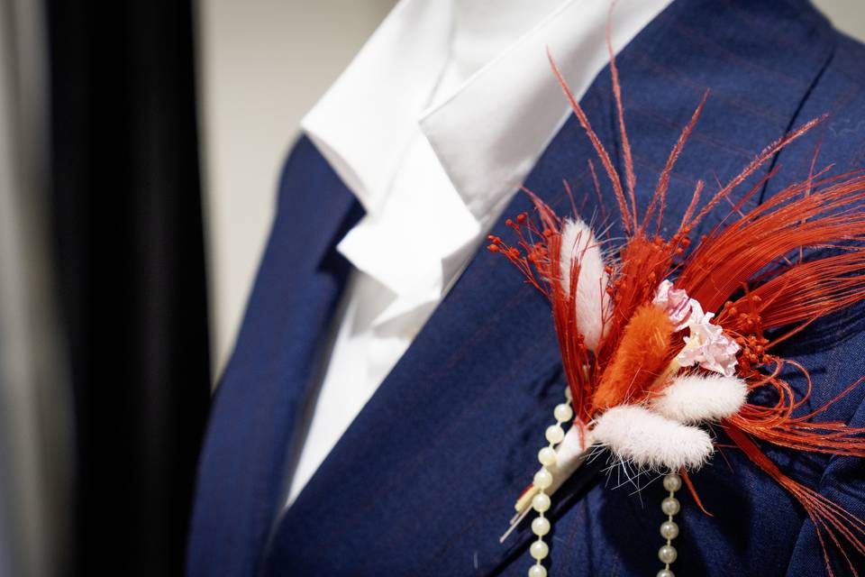 Boutonniere_plumes_rouges_perles_blanches_costume_bleu