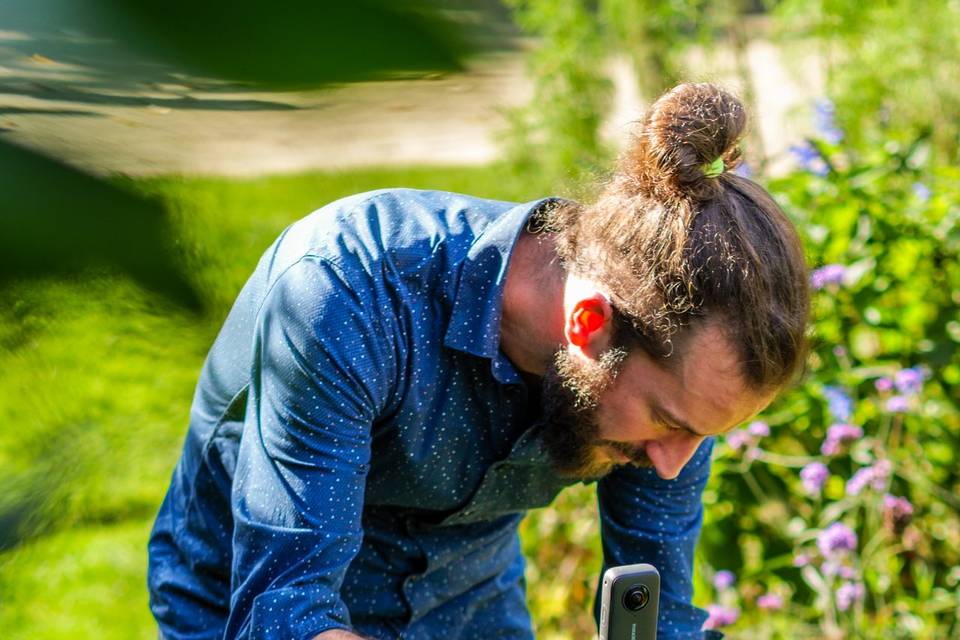 Detail_homme_filmant_dans_un_jardin