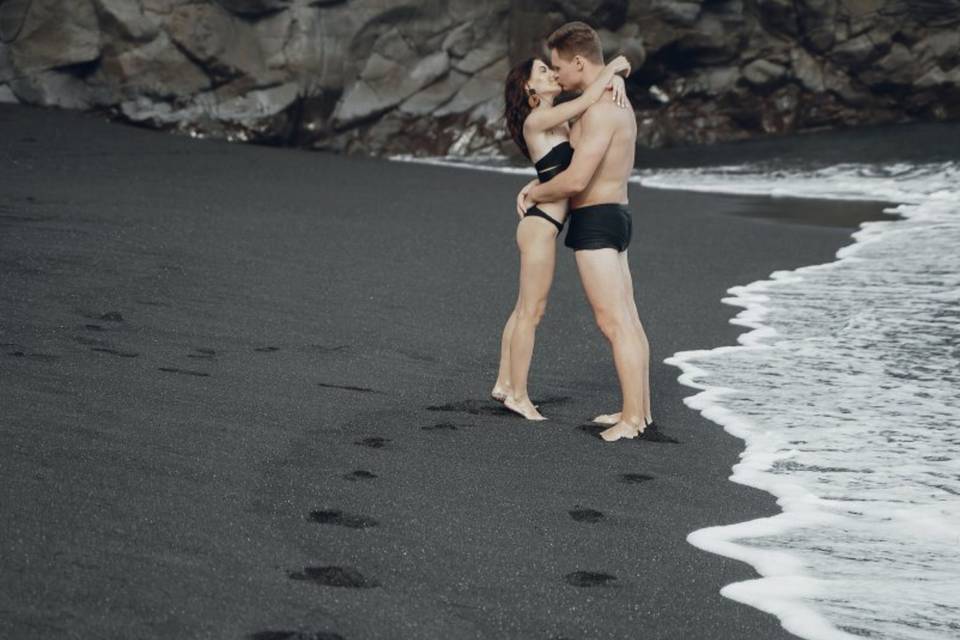 Couple sur plage de sable noir